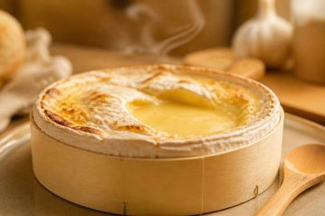 Mont d’Or dans sa boîte en épicéa sortant du four, croûte dorée et coeur coulant
