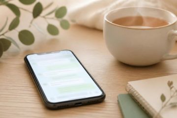 Téléphone posé sur une table en bois affichant une conversation de messagerie